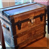 F25. Small trunk with metal bracings and leather handles. 19”h x 21”w x 16”d 